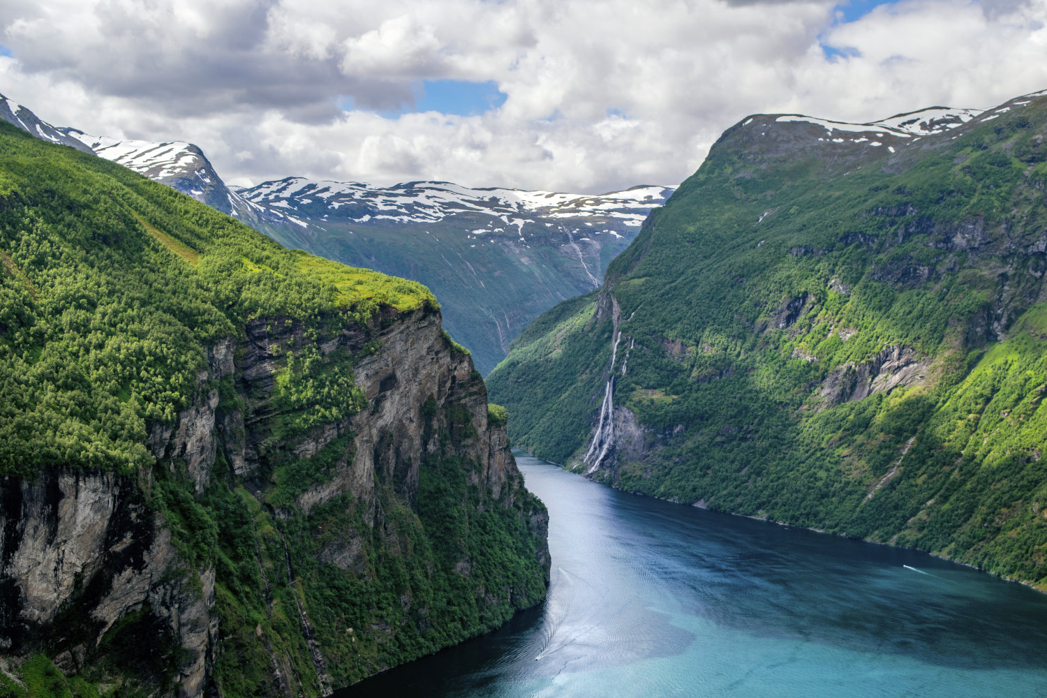 Ein Fjord mit bewaldten Hängen in Norwegen.